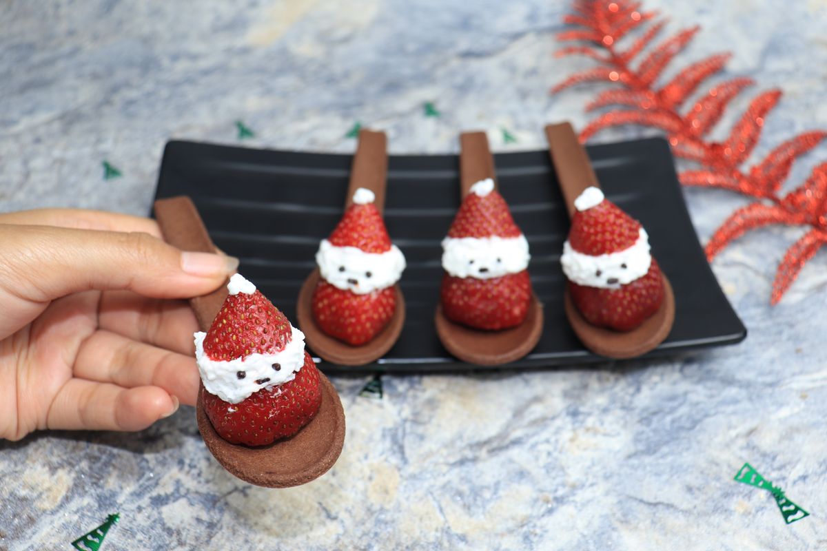 Strawberry Santa desserts with whipped cream on chocolate cookie spoons